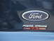 2003 Ford Excursion - Close-up of a Ford oval badge and Power Stroke Turbo 7.3 Diesel emblem on the rear of a dark blue vehicle.