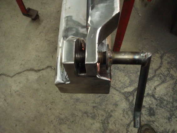 Metal clamp with threaded rod and handle, on concrete floor
