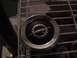 1986 Ford Bronco - Close-up of an Opel emblem, a gear and lightning bolt, mounted on a vehicle's grille.