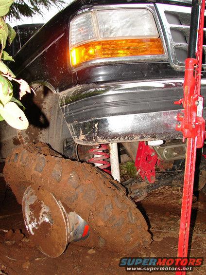 Ford F-Series truck stuck in mud with a jack next to it
