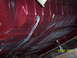 1960 Ford Falcon - The undercarriage of a red vehicle is shown, with prominent structural ribs and fuel lines visible.