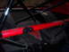 1984 Ford Bronco - The interior of a race car is visible, a prominent red bar and black roll cage structure.