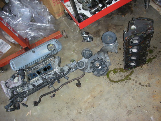 Engine block and intake manifold disassembled on concrete floor