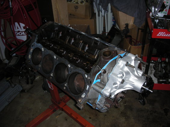 Engine block on a red stand, with gasket material visible
