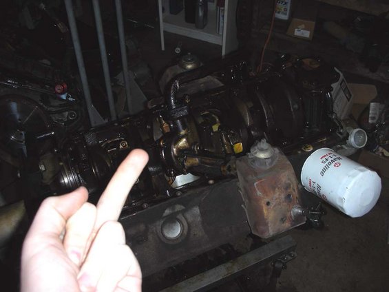 engine block with oil filter and a hand giving the finger