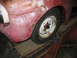 1952 Ford Pickup - Close-up of a 1952 Ford Pickup's front fender and wheel, with visible rust.