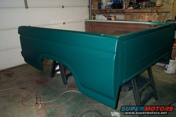 Green truck bed on sawhorses in a garage
