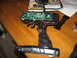1990 Ford Bronco - A disassembled remote control transmitter lies on a wooden table, revealing its internal electronic components.