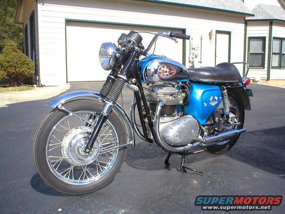 Blue motorcycle with chrome fenders and a badge reading '384'