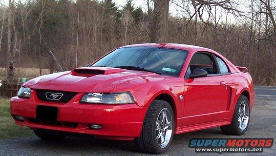 Red 2004 Ford Mustang coupe with a hood scoop, chrome wheels, and a spoiler, viewed from the front three-quarter angle