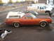 1979 Ford Ranchero - A side view of a brown Ford Ranchero pickup truck, fitted with a white camper shell, parked outdoors.