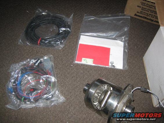 differential and two wiring harnesses laid out on carpet, with a box in background