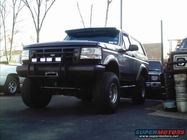 Black Ford Bronco with aftermarket grille guard and light bar, lifted suspension, and large tires