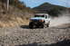 1992 Ford Explorer - This modified 1992 Ford Explorer competes in an off-road race, kicking up a cloud of dust on a gravel road.