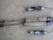 1985 Ford Bronco II - A collection of Fox Racing Shox shock absorbers, including two longer, weathered units and a shorter, black unit with a braided hose.