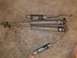 1985 Ford Bronco II - Four shock absorbers are laid out on a textured surface, showing signs of wear and tear.