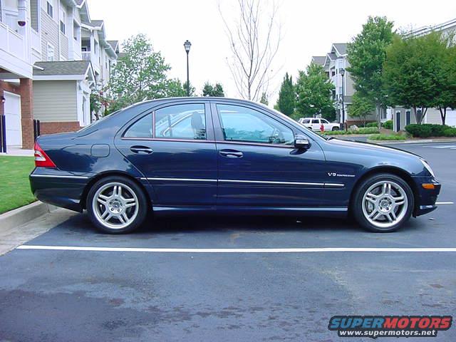 Dark blue sedan side view with V8 badge on fender