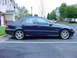 1984 BMW 3 Series - A dark blue sedan is parked in a lot, showing its side profile and V8 badging on the front fender.