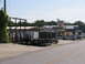 1995 Ford C-350 (Centurion Conversions) - A silver pickup truck is parked in an industrial area with several trailers and buildings visible.