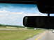 1995 Ford C-350 (Centurion Conversions) - Driving on a highway with a clear sky and green fields visible through the windshield.