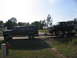 1995 Ford C-350 (Centurion Conversions) - A black Ford Bronco is transported on a trailer pulled by a dark-colored Ford Econoline van.