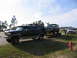 1995 Ford C-350 (Centurion Conversions) - Ford Econoline van towing a Ford Bronco on a trailer, with a white pickup truck in the background.