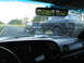 1995 Ford C-350 (Centurion Conversions) - A black Ford Bronco is towed on a trailer behind another vehicle on the highway.