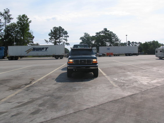 1995 Ford C-350 (Centurion Conversions) pickup truck parked in a lot with semi-trailers