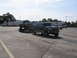 1995 Ford C-350 (Centurion Conversions) - A Ford F-Series truck tows a Ford Bronco on a trailer in a parking lot.
