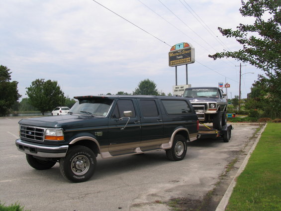 Dark green 1995 Ford C-350 Centurion Conversion towing a pickup truck