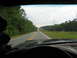 1995 Ford C-350 (Centurion Conversions) - Driving down a long, straight road with trees lining both sides and a white car ahead.