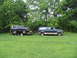 1995 Ford C-350 (Centurion Conversions) - A Ford Bronco is loaded onto a trailer and towed by a Ford Excursion in a grassy area.