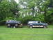1995 Ford C-350 (Centurion Conversions) - A dark blue Ford Bronco is loaded onto a trailer, which is then towed by a green Ford Econoline SUV.