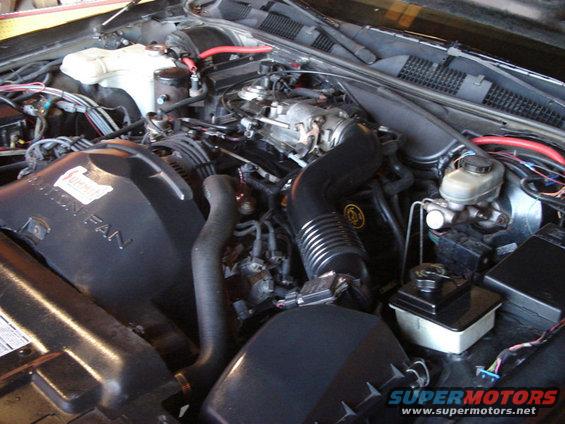 Engine bay with V8 engine, air intake, radiator fan shroud, and brake fluid reservoir