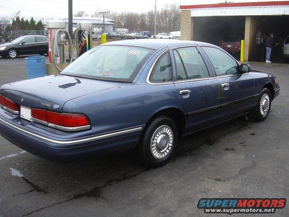 Blue 1996 Ford Crown Victoria sedan parked at a car wash, rear 3/4 view