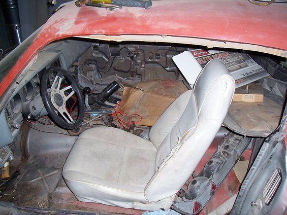 Interior of a 1979 Chevrolet Camaro with ripped passenger seat and exposed dashboard