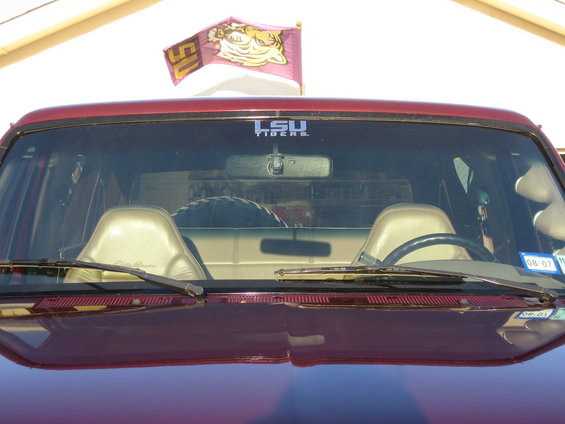Interior view of a red SUV with LSU Tigers flag and decal