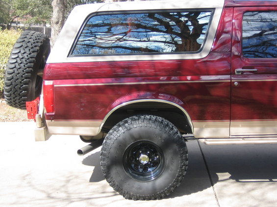 Red and tan 1996 Ford Bronco rear quarter panel with spare tire