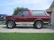 1996 Ford Bronco - Side profile of a maroon 1996 Ford Bronco, a two-tone paint scheme with a tan removable top.