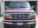 1996 Ford Bronco - Front view of a maroon 1996 Ford Bronco parked in front of a garage.