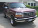 1996 Ford Bronco - Maroon 1996 Ford Bronco parked in front of a garage and house.