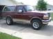 1996 Ford Bronco - This Ford Bronco is parked in a driveway with a house and trees in the background.