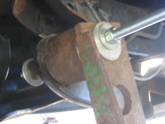 Close-up of a rusted metal bracket with a bolt and washers, part of a lift installation