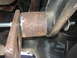1996 Ford Bronco - Close-up of a rusty lift kit component, showing a bolt and washer securing it to a vehicle's suspension.