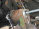 1996 Ford Bronco - Close-up of a wrench being used to install a suspension component on a vehicle.