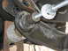 1996 Ford Bronco - A close-up view of a vehicle's suspension component undergoing installation or adjustment.