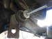 1996 Ford Bronco - Close-up view of a suspension component with a threaded rod being installed, likely for a lift kit.