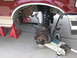 1996 Ford Bronco - The suspension of a maroon Ford Bronco is visible, supported by jack stands and a hydraulic jack.