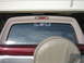 1996 Ford Bronco - The rear of a maroon and silver SUV is shown, a spare tire cover and an LSU decal on the window.