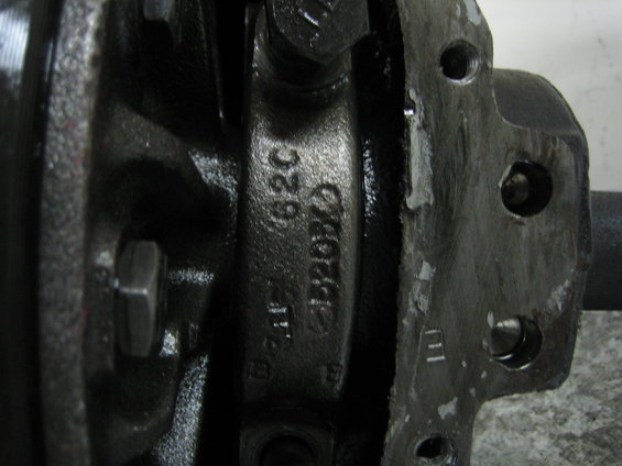 Close-up of a metal automotive part with casting numbers like "62C" and "F4208D"